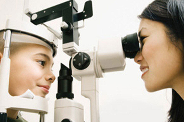 Vision Centre associate checks a patient's eyes.L'associé du Centre de vision vérifie les yeux d'un patient.