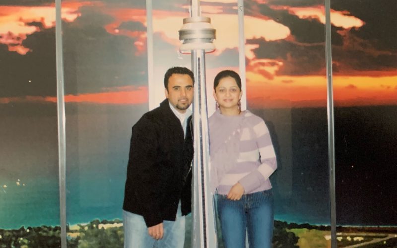 Shahpoor Amiri and his wife, Zainab Amiri, pose beside a CN Tower model in Toronto in the 2000s.
