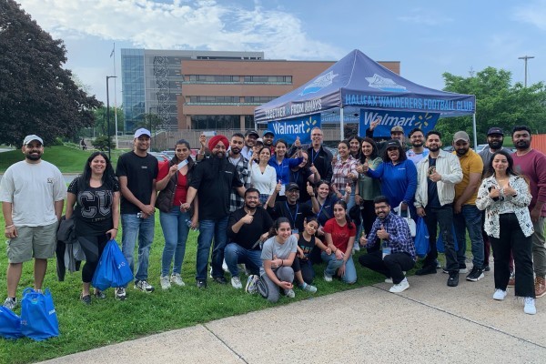 Photo de groupe de nouveaux associés canadiens sous une tente Walmart.
